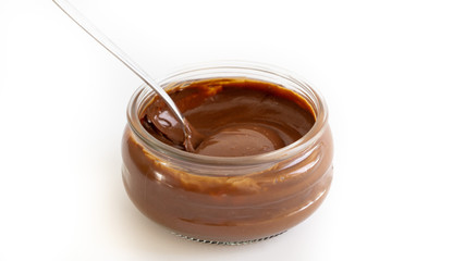 Chocolate mousse  in a jar. There is spoon in it. Isolated. White background. 