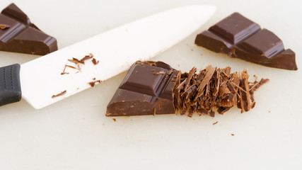 Chocolate bar chopped with knife. Knife is near it. 
