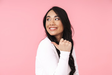 Image of young brunette asian woman smiling and pointing fingers aside