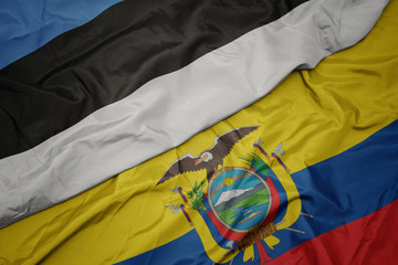 waving colorful flag of ecuador and national flag of estonia.