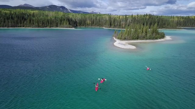 Tourists Enjoy Kayaking In Caribbean Blue Water Near A Small Island With Beautiful Trees In Canada - Aerial shot
