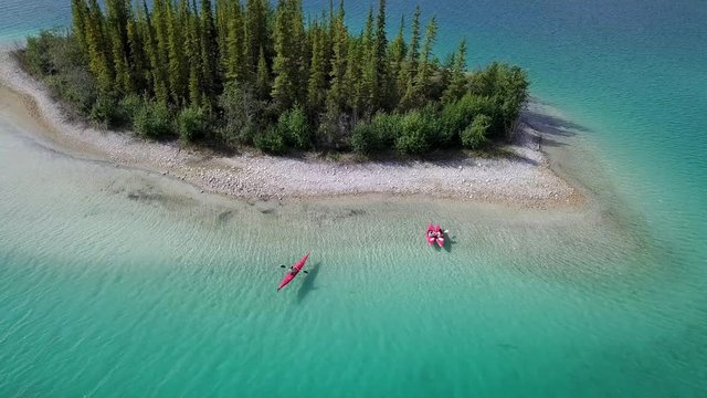 Tourists Enjoy Kayaking In Caribbean Calm Sea Near A Small Island In Boya Lake, British Columbia Canada - Perfect For Summer Activities - Aerial shot