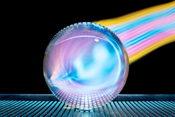 A studio photo of a crystal ball with lots of reflections. Like a comet, the glass ball apparently...