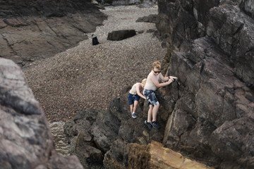 Two boys exploring rocks at the beach