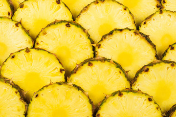 Pineapple juicy yellow slices background. Top view.
