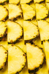 Pineapple juicy yellow slices background. Top view.