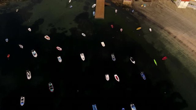 Aerial tilt up reveal of boats in Redes village and natural park, Spain