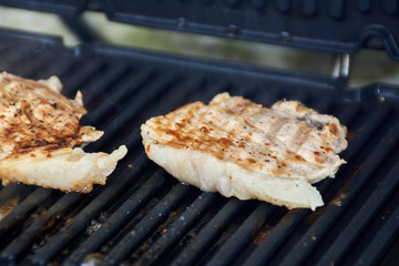 Grilled cooking. Grilled chicken breast lies on the grill.