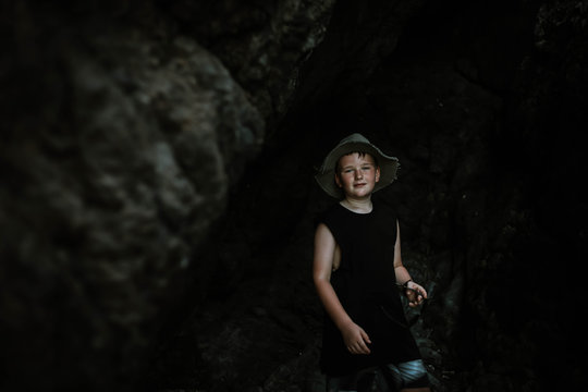 Young boy exploring cave by the beach at Coral Beach near Shute Harbour in the Whitsundays, Queensland Australia