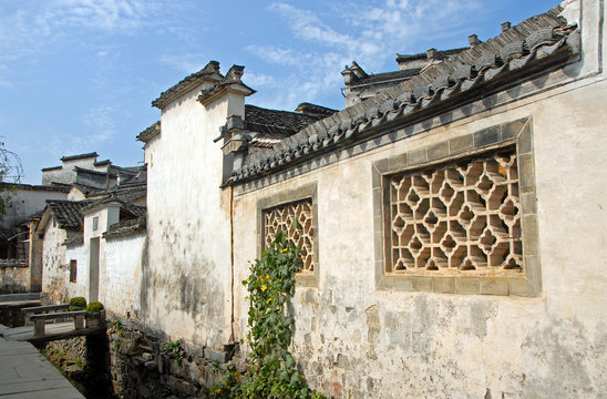 Xidi Ancient Town in Anhui Province, China. A quiet street in the old town of Xidi called the Back Rivulet. This path follows a small stream past local houses. Traditional architecture in Xidi, China.