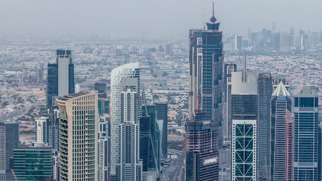 Dubai Downtown skyline futuristic cityscape with many skyscrapers and business bay aerial night to day transition timelapse. Morning panorama with modern towers and construction from rooftop before
