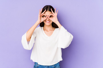 Young caucasian woman isolated on purple background excited keeping ok gesture on eye.