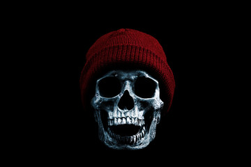 Frozen skull in red winter hat isolated on black background. Cold weather concept.