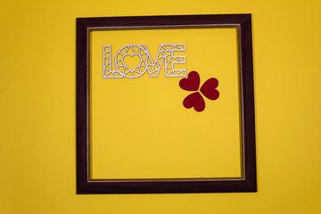 On a yellow background in the frame the word "Love" and three red hearts.