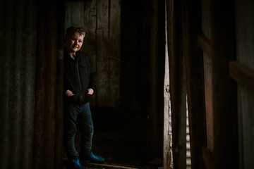 Young boy in dark hallway with dim light on face