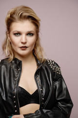 Fototapeta premium Woman blonde in leather jacket looking at camera isolated in studio