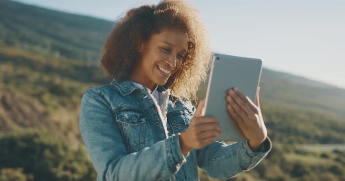Young attractive african american woman taking pictures with her tablet outdoors in the afternoon, african american woman using technology and exploring the great outdoors