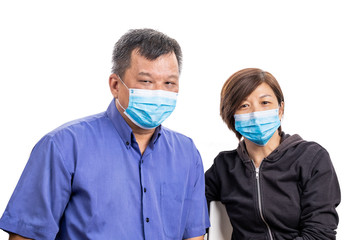 Fototapeta na wymiar Concerned mature Asian Chinese couple with face mask for protection against influenza virus