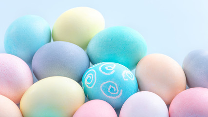 Colorful Easter eggs dyed by colored water isolated on a pale blue background, design concept of Easter holiday activity, close up, copy space.