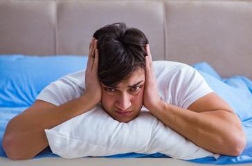 Man suffering from insomnia lying in bed