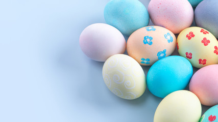 Fototapeta na wymiar Colorful Easter eggs dyed by colored water isolated on a pale blue background, design concept of Easter holiday activity, close up, copy space.