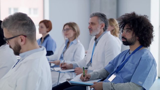 Group of doctors listening to presentation on medical conference.