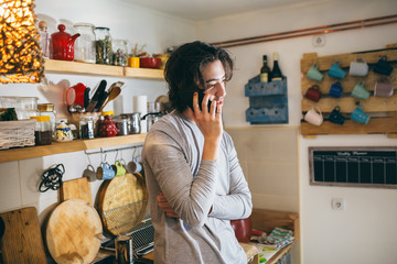 young man talking on cell phone in kitchen