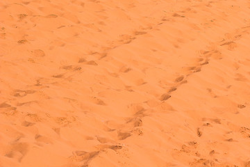 desert sand wavy background textured surface with shoes foot steps prints on a ground