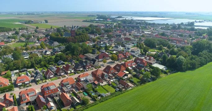 Dutch City Sexbierum, Showing a Neighbourhoord, a Church (Sixtuskerk) and Greenhouses, Shot Moving Backwards and Right, Friesland, Netherlands / Holland &ndash; 4K Drone Footage