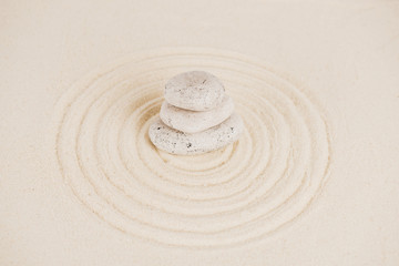 Fototapeta na wymiar Stack of zen stones on sand surface with circles