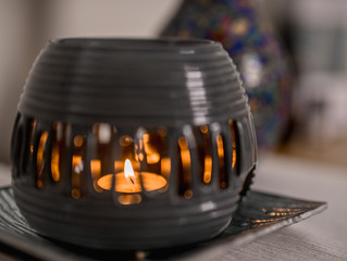 Aroma lamp with burning candle and essential oil on a plate. Spa room hotel.