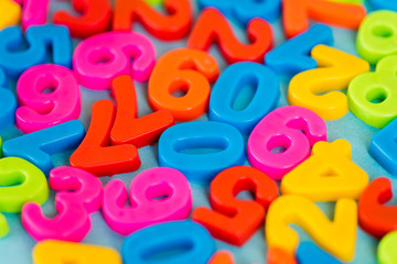 Selective focus of colorful plastic numbers on blue surface