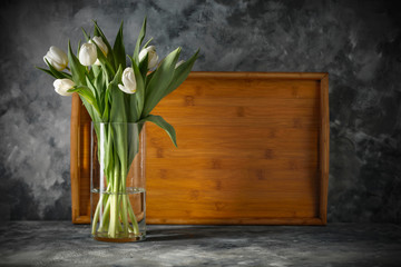 Dark mood background and fresh flowers of tulips.