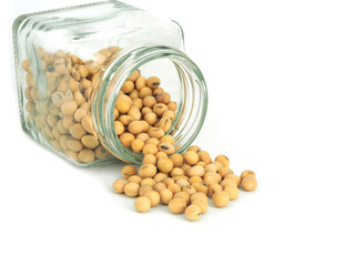 Overturned glass jar with soybeans isolated on white background..