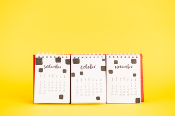 Paper calendar with september, october and november months on yellow background