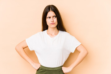 Obraz premium Young caucasian woman isolated on beige background confused, feels doubtful and unsure.