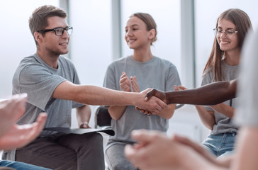 Fototapeta premium handshake of young people in a circle of like-minded people.
