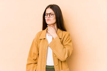 Young caucasian woman isolated on beige background suffers pain in throat due a virus or infection.