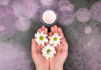 Top view and flat lay of a woman holding a cream in her hands over a blue background. Natural creams for healthy skin. Natural cosmetic. The concept of natural medicine. Eco medicine. flat lay