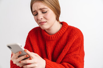 Displeased young woman using mobile phone.