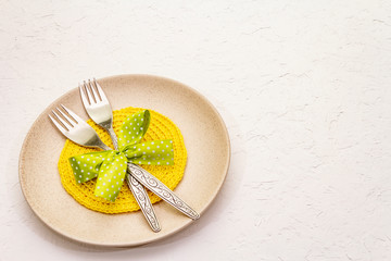 Easter table setting on textured white putty background. Spring holiday card template. Cutlery,...