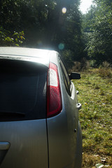 Shiny car with silver paint. Water drops on the hood.