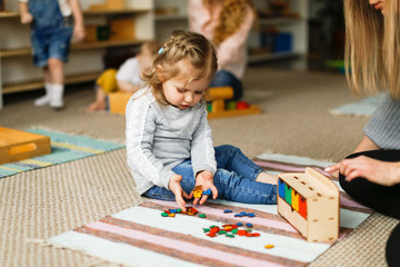 Caucasian toddler girl playing Montessori center