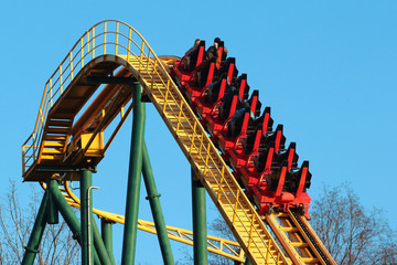 Roller coaster against blue sky background. Amusement park attractions.