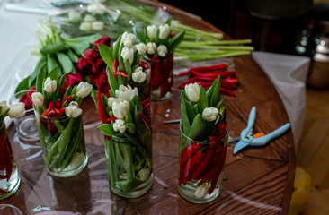 horizontal photo of a table with many flower arrangements