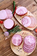 Assorted bacon, ham and olives on brown wooden table