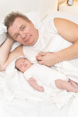 dad with a newborn baby resting