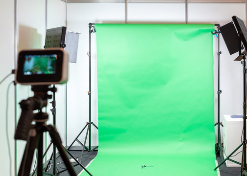Green screen studio background. Filming or photography studio set with lights and filming equipment