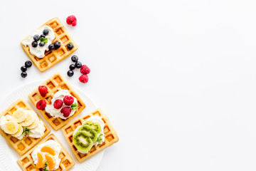 Breakfast with freashly baked belgian waffles on white background top-down frame copy space