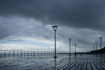 Fototapeta premium Lanterns on the embankment after rain and cloudy sky
